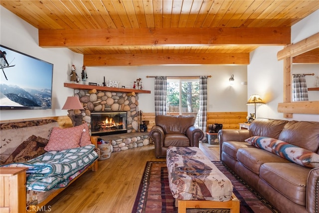 living room featuring a fireplace, light wood-type flooring, beamed ceiling, and wood ceiling