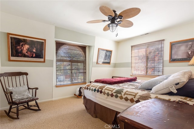 bedroom featuring ceiling fan, light carpet, and multiple windows