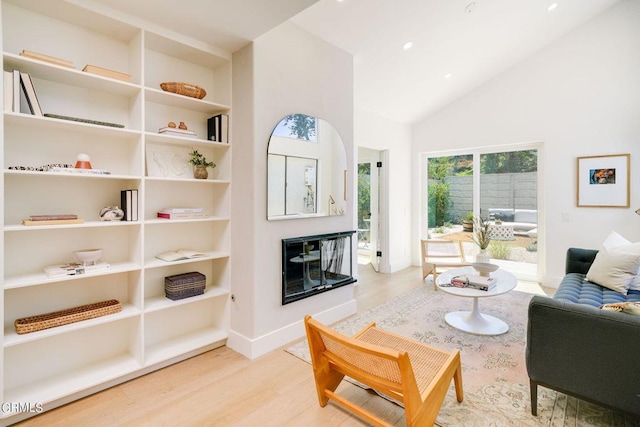 living room with light wood-type flooring and high vaulted ceiling