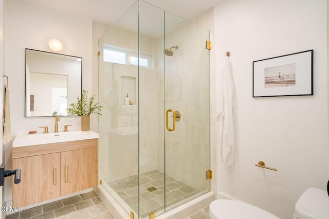 bathroom featuring tile patterned flooring, walk in shower, vanity, and toilet