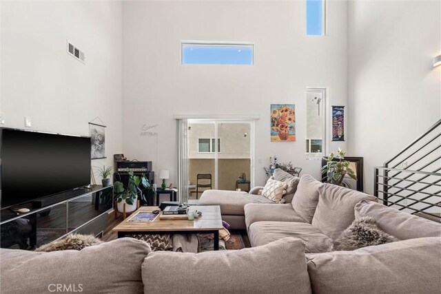 living room featuring hardwood / wood-style floors, a high ceiling, and plenty of natural light