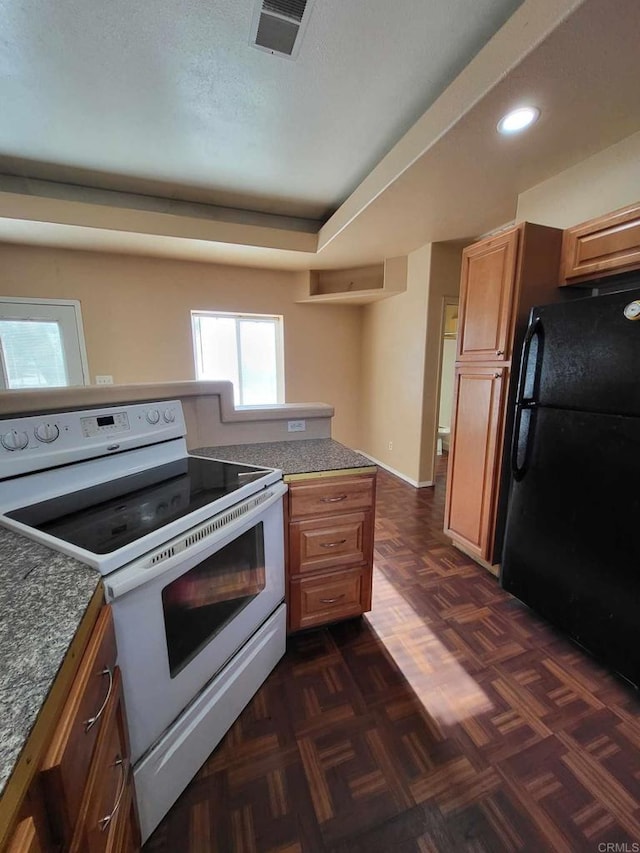 kitchen featuring white electric range, dark parquet flooring, and black refrigerator