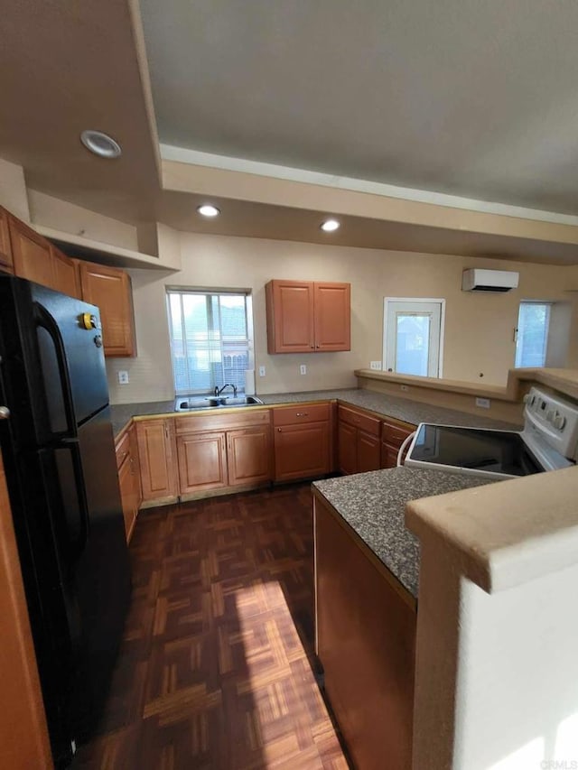 kitchen with white range, black fridge, sink, kitchen peninsula, and a wall mounted AC