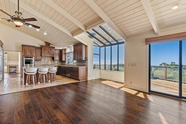 kitchen featuring light hardwood / wood-style flooring, a center island, lofted ceiling with beams, a kitchen bar, and decorative backsplash