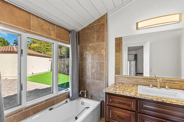 bathroom with vaulted ceiling, a bathing tub, tile walls, vanity, and wood ceiling