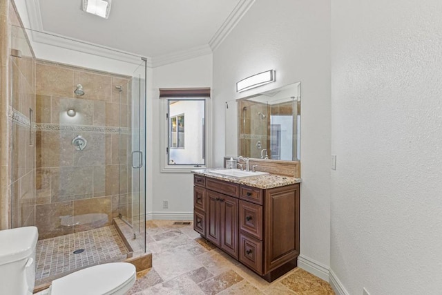 bathroom with a shower with door, ornamental molding, vanity, and toilet