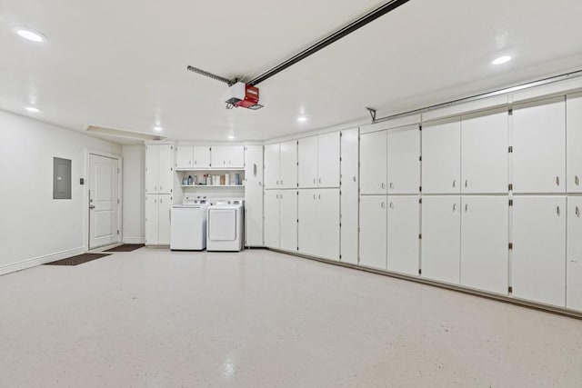 garage with a garage door opener, electric panel, and washer and clothes dryer