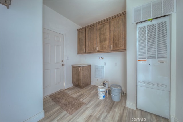 laundry room with light hardwood / wood-style flooring, washer hookup, and cabinets