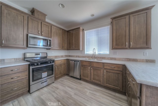 kitchen featuring sink, light wood-type flooring, and stainless steel appliances