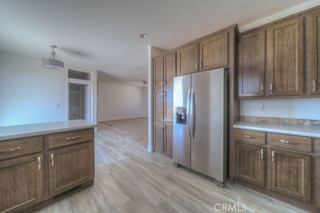 kitchen featuring stainless steel refrigerator with ice dispenser and light hardwood / wood-style flooring