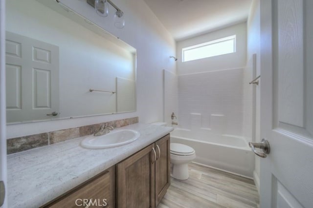 full bathroom with toilet, washtub / shower combination, vanity, and wood-type flooring