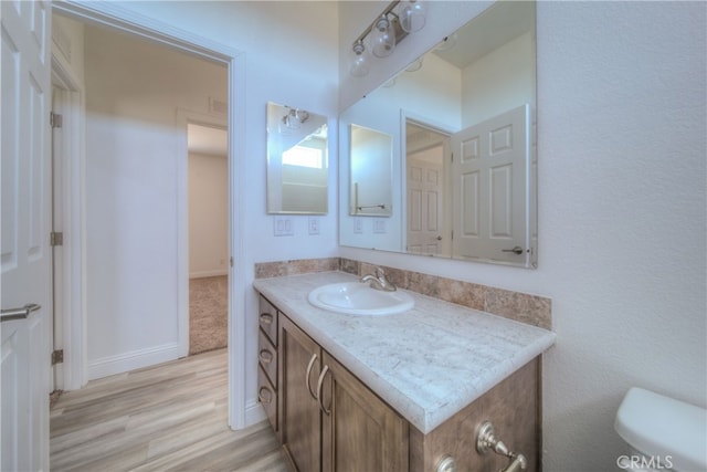 bathroom featuring vanity, hardwood / wood-style floors, and toilet