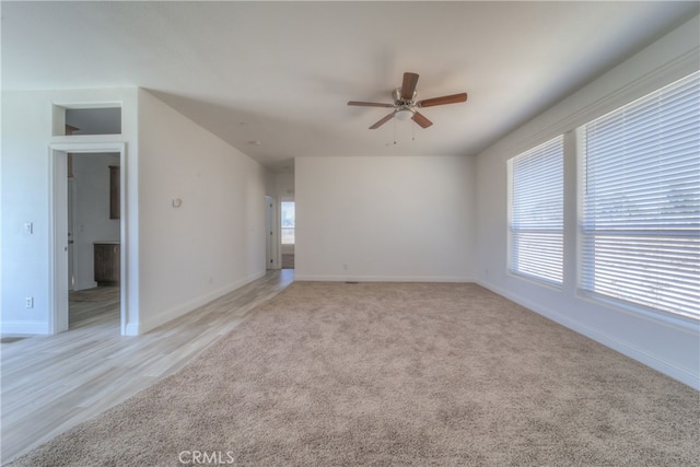 carpeted empty room with ceiling fan and a healthy amount of sunlight