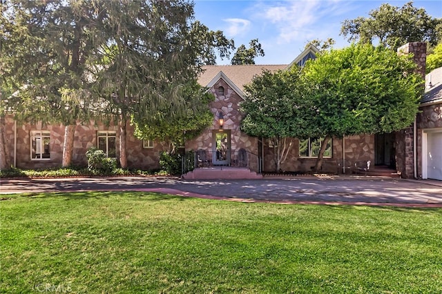 view of property hidden behind natural elements with a front lawn