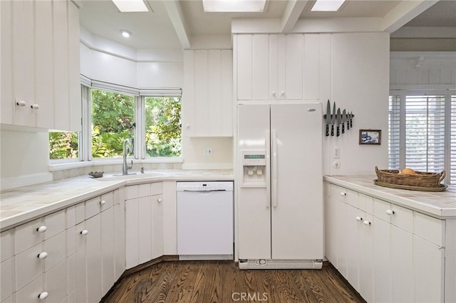 kitchen with dark wood-type flooring, white appliances, white cabinets, and sink