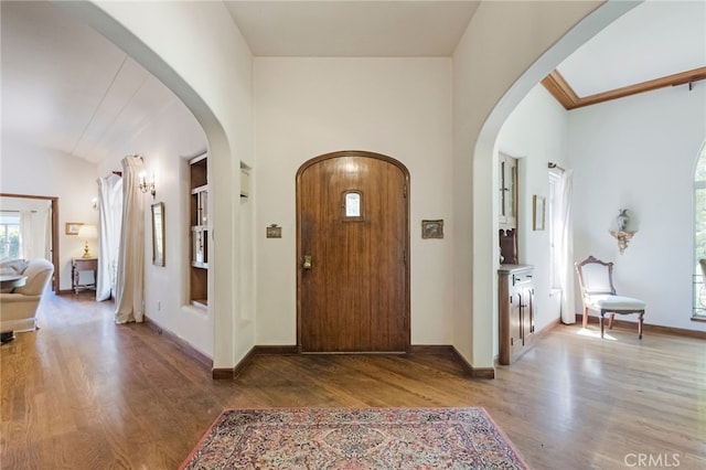 entryway featuring wood-type flooring and crown molding