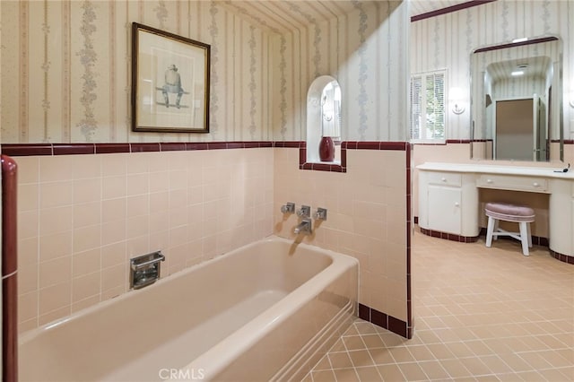 bathroom with a tub to relax in, tile walls, and tile patterned flooring