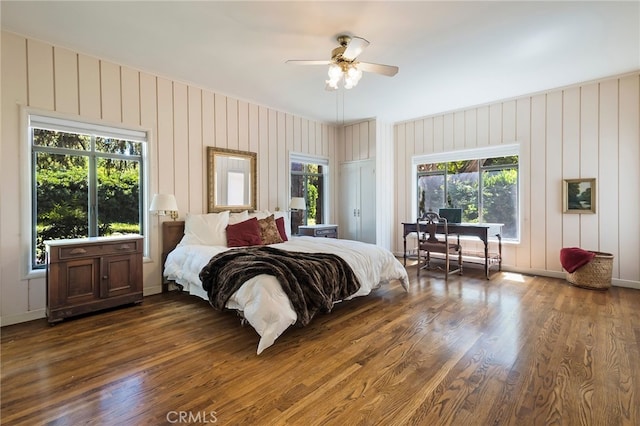 bedroom with ceiling fan, dark hardwood / wood-style flooring, and multiple windows