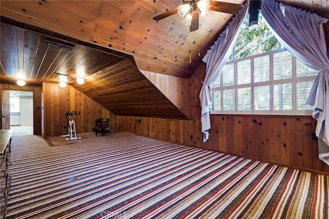 additional living space with carpet, lofted ceiling, wood ceiling, wooden walls, and ceiling fan