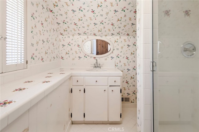 bathroom featuring a shower with shower door, vanity, and tile patterned flooring