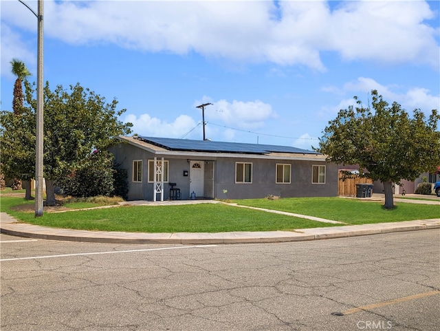 ranch-style house featuring solar panels and a front lawn