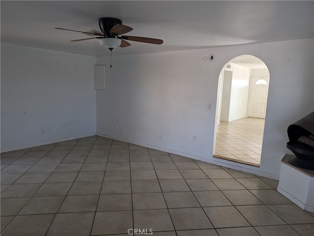 tiled spare room with ceiling fan