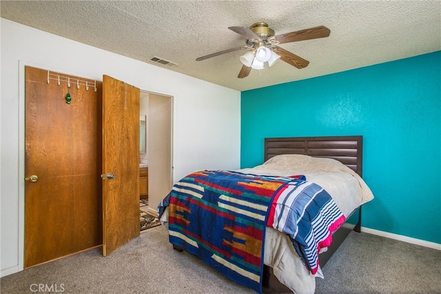 carpeted bedroom featuring ceiling fan and a textured ceiling