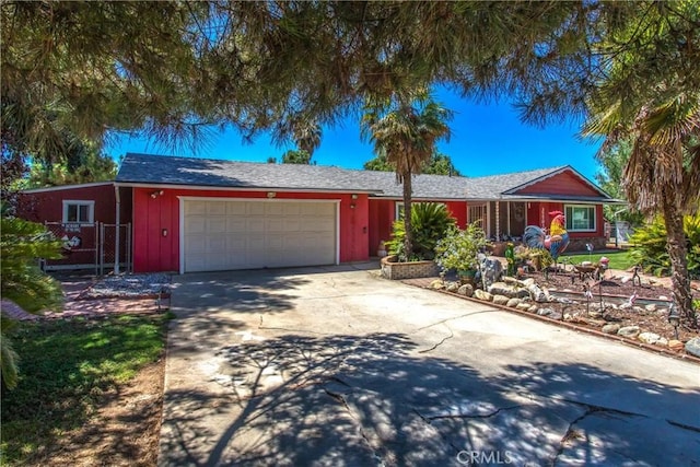 single story home with a garage, concrete driveway, and fence