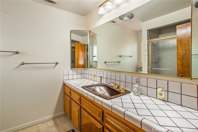 bathroom with tile patterned flooring, tasteful backsplash, and vanity