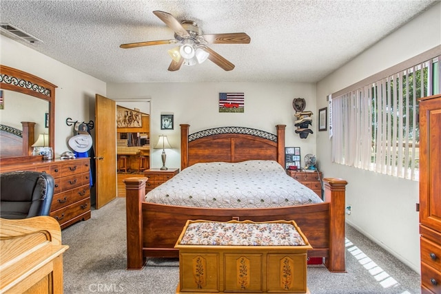 bedroom featuring ceiling fan, a textured ceiling, and light carpet