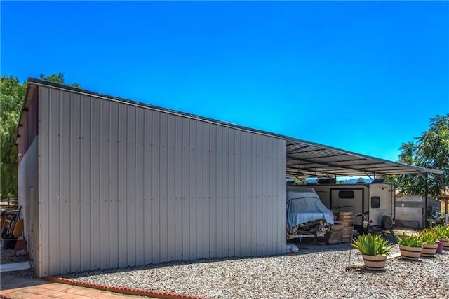 view of side of home featuring an outbuilding, a carport, and a pole building