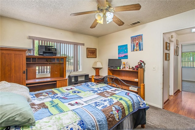 carpeted bedroom featuring a textured ceiling and ceiling fan