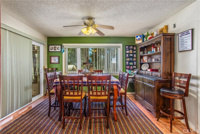 dining area featuring a textured ceiling, ceiling fan, and hardwood / wood-style floors