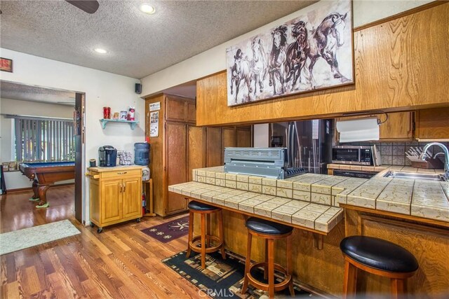 kitchen featuring tile countertops, billiards, sink, and hardwood / wood-style flooring