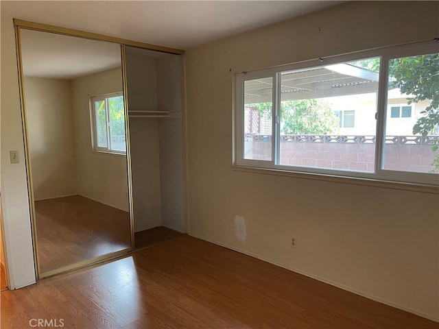 unfurnished bedroom featuring a closet and hardwood / wood-style floors