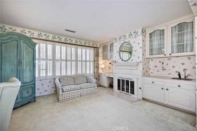 sitting room with light carpet, wallpapered walls, and visible vents