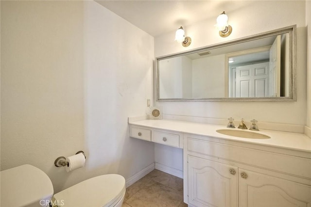 bathroom with toilet, baseboards, vanity, and tile patterned floors