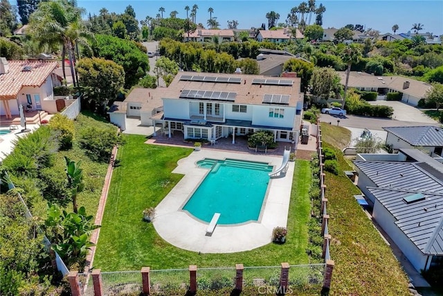 view of swimming pool featuring a fenced in pool, a fenced backyard, a residential view, a patio area, and a diving board