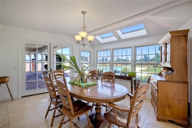 dining area featuring a skylight, a chandelier, and light tile patterned flooring