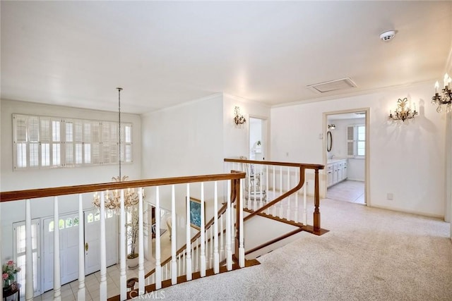 hall featuring a chandelier, light carpet, an upstairs landing, baseboards, and crown molding