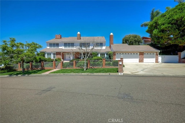 view of front of property with a garage, concrete driveway, and a fenced front yard