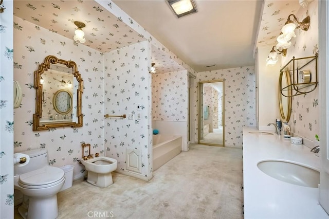 bathroom featuring wallpapered walls, toilet, a washtub, vanity, and a bidet