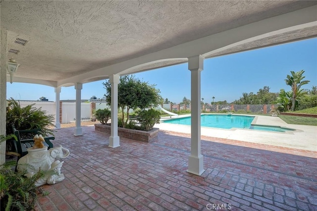 exterior space featuring a water slide, a patio area, fence private yard, and a fenced in pool