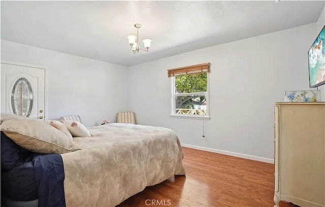 bedroom featuring wood-type flooring and a chandelier