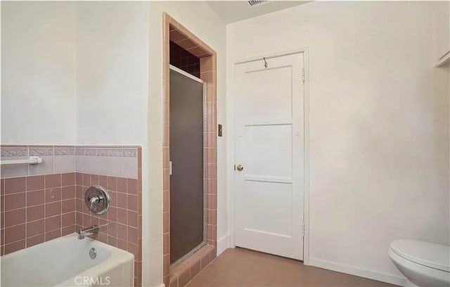 bathroom with toilet, tile patterned floors, and separate shower and tub