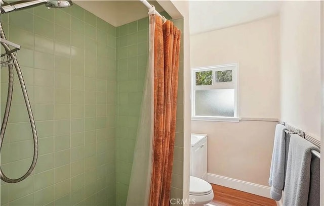 bathroom with toilet, a shower with shower curtain, and hardwood / wood-style flooring