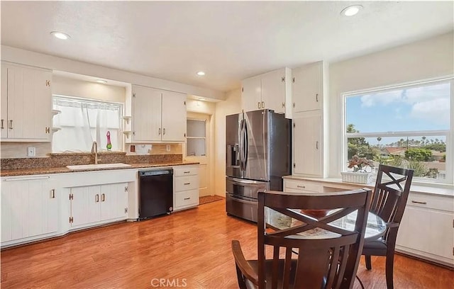 kitchen featuring white cabinetry, dishwasher, stainless steel fridge, and sink