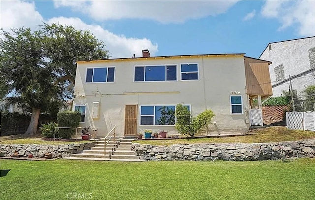 rear view of house featuring a lawn