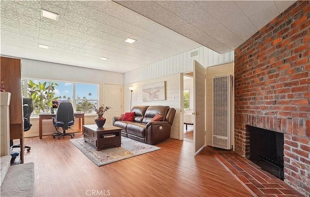 living room with wood-type flooring and a fireplace