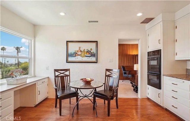 kitchen with white cabinets, a healthy amount of sunlight, and light hardwood / wood-style flooring